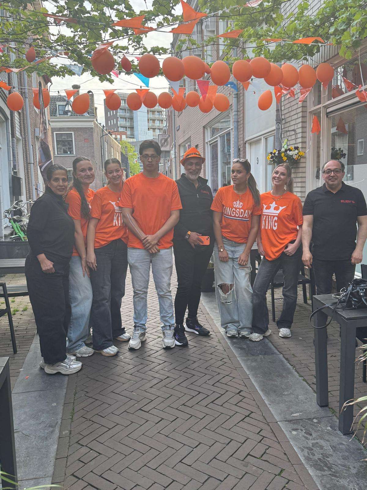 Het team van RUBY'S in oranje shirts in de versierde Lindenstraat